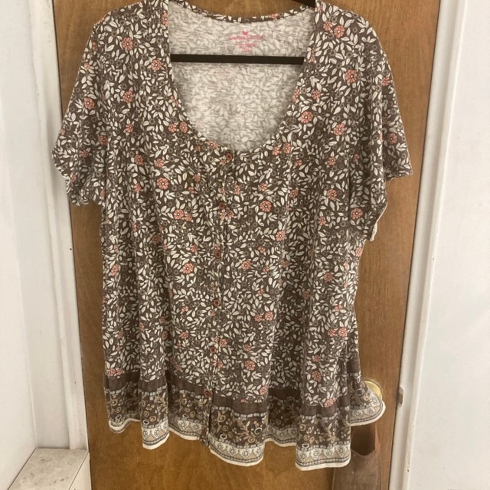 Woman within button down blouse with ruffled hem.